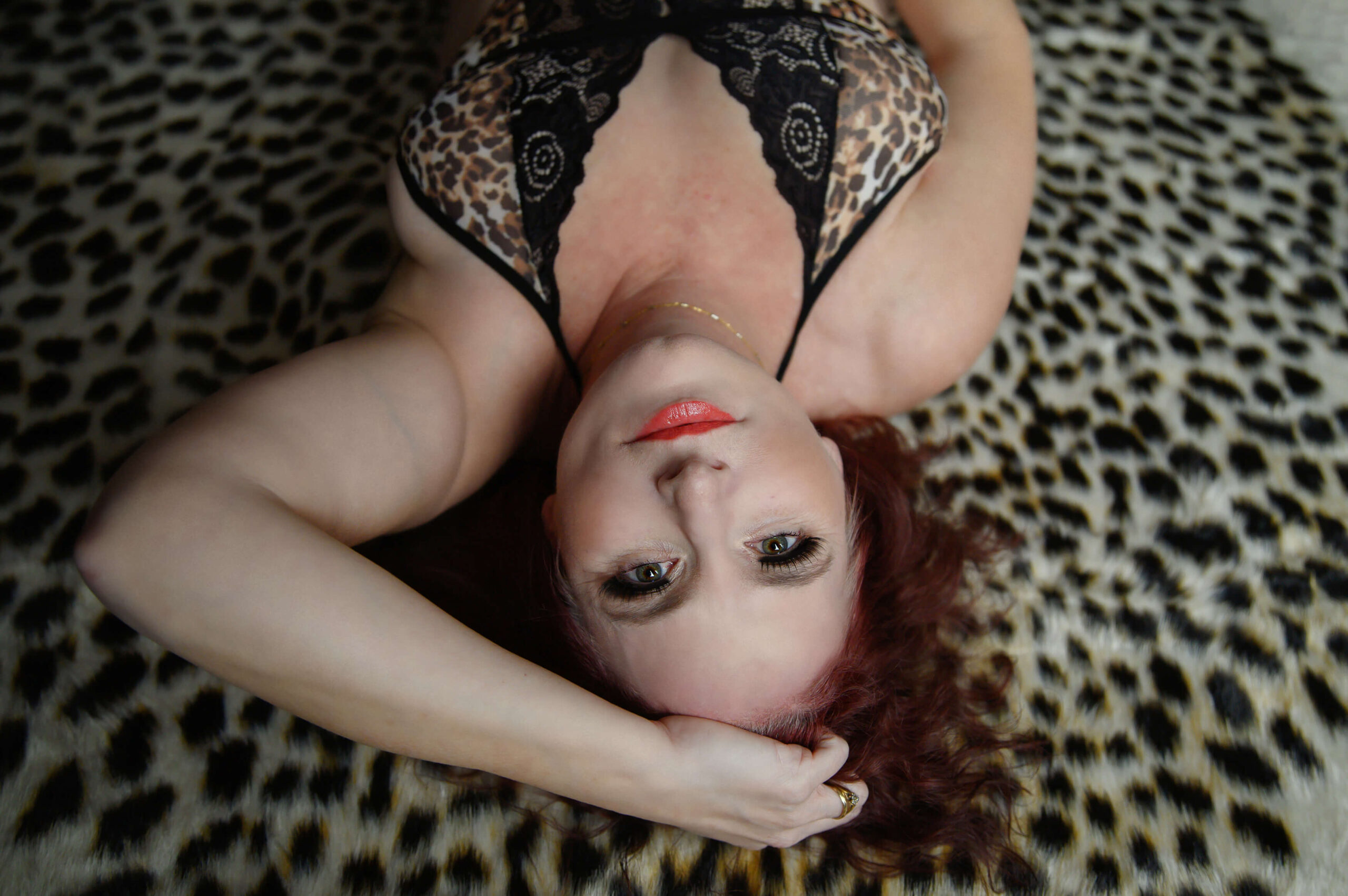 Woman wearing cheetah print lying down on a cheetah rug for her Botox Toronto Boudoir photography session.