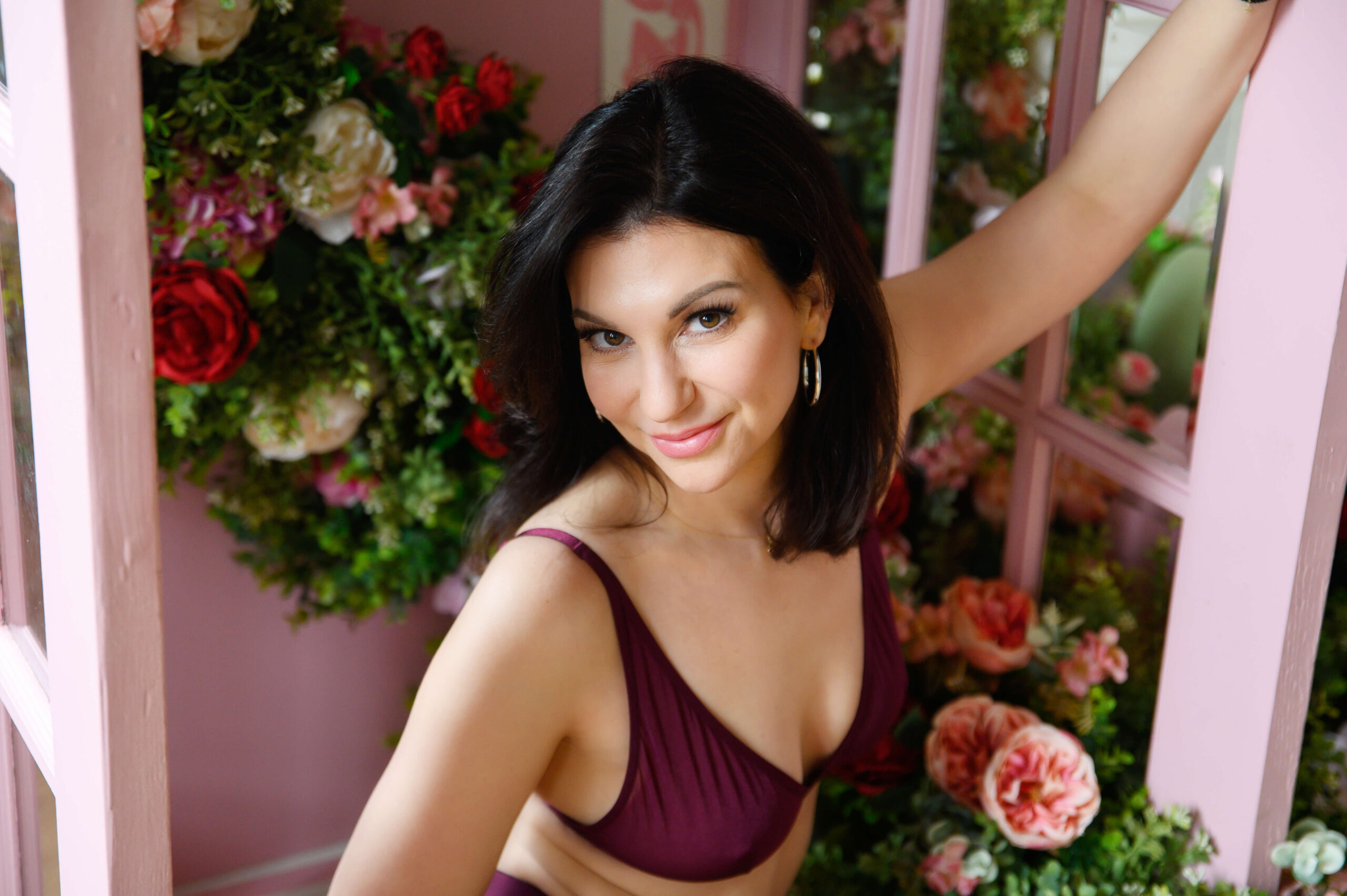 Oakville hair salon soft glam waves boudoir client. Brown haired woman wearing purple bra with flowers around her.